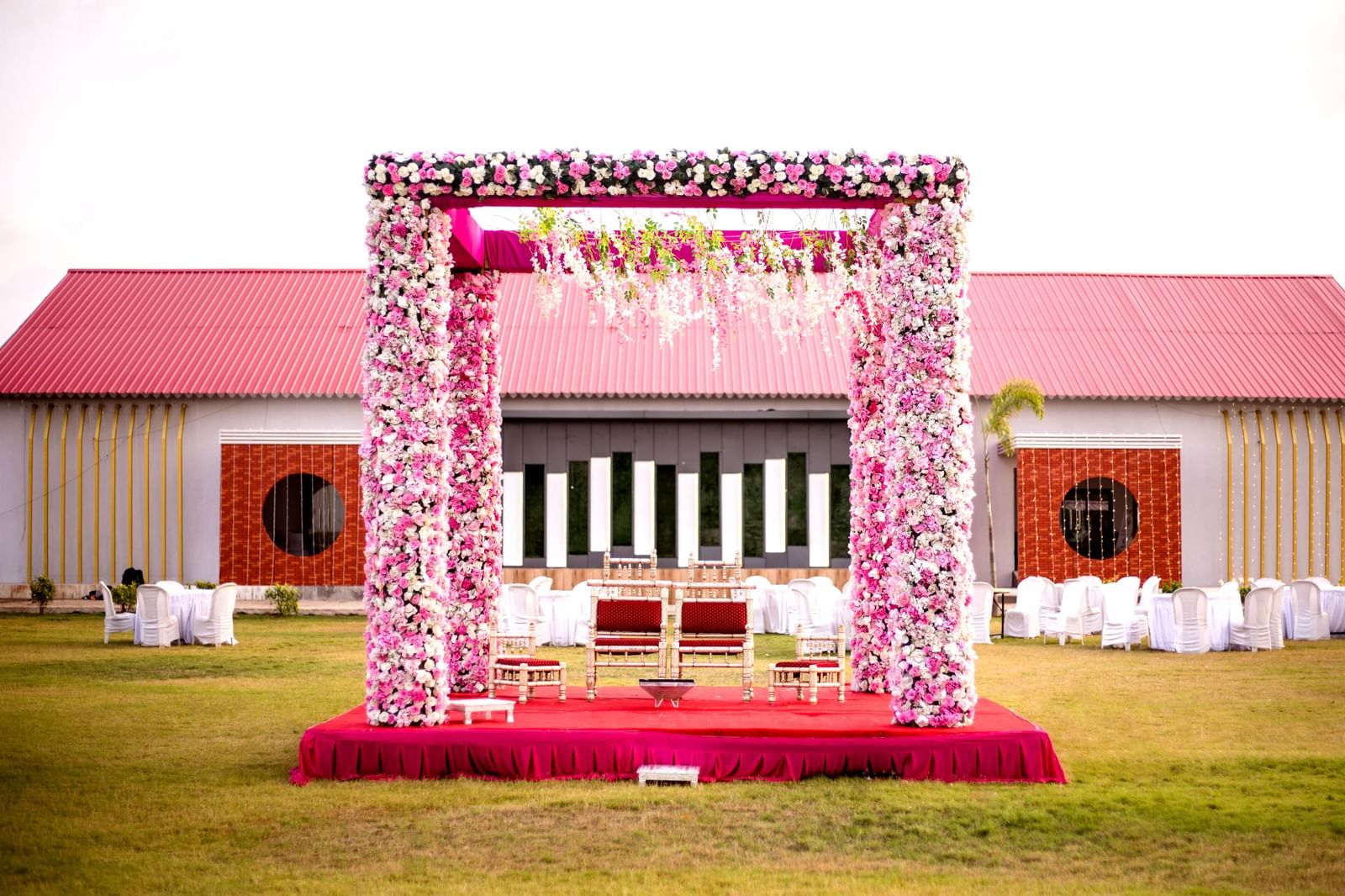 Lawn wedding mandap at Daksh Hotels and Resorts, adorned with pink flowers.