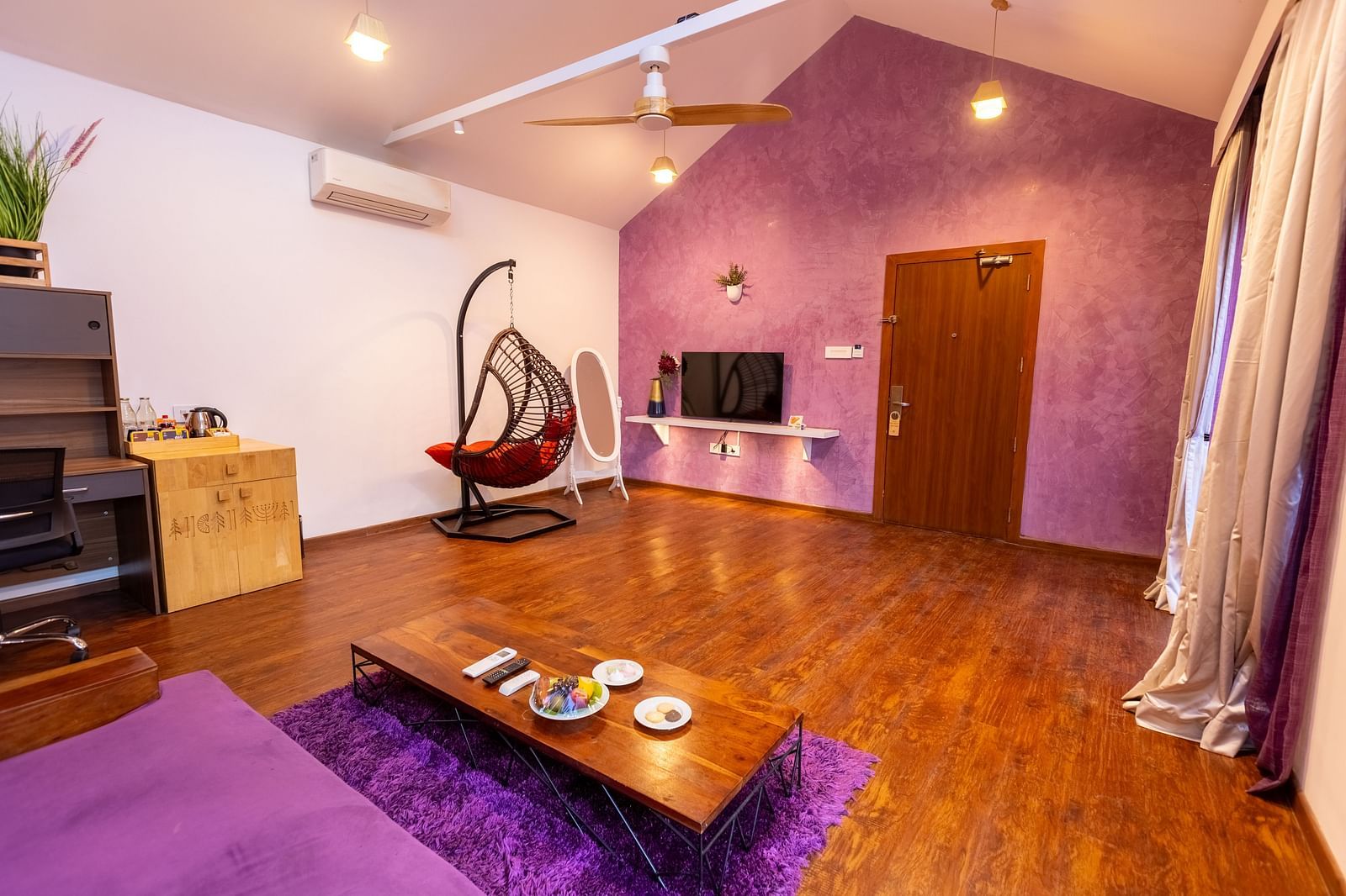 full view image of the living room at the Grand Pool Villa with a coffee table in front of the couch and a wall mounted tv - Darza Resorts