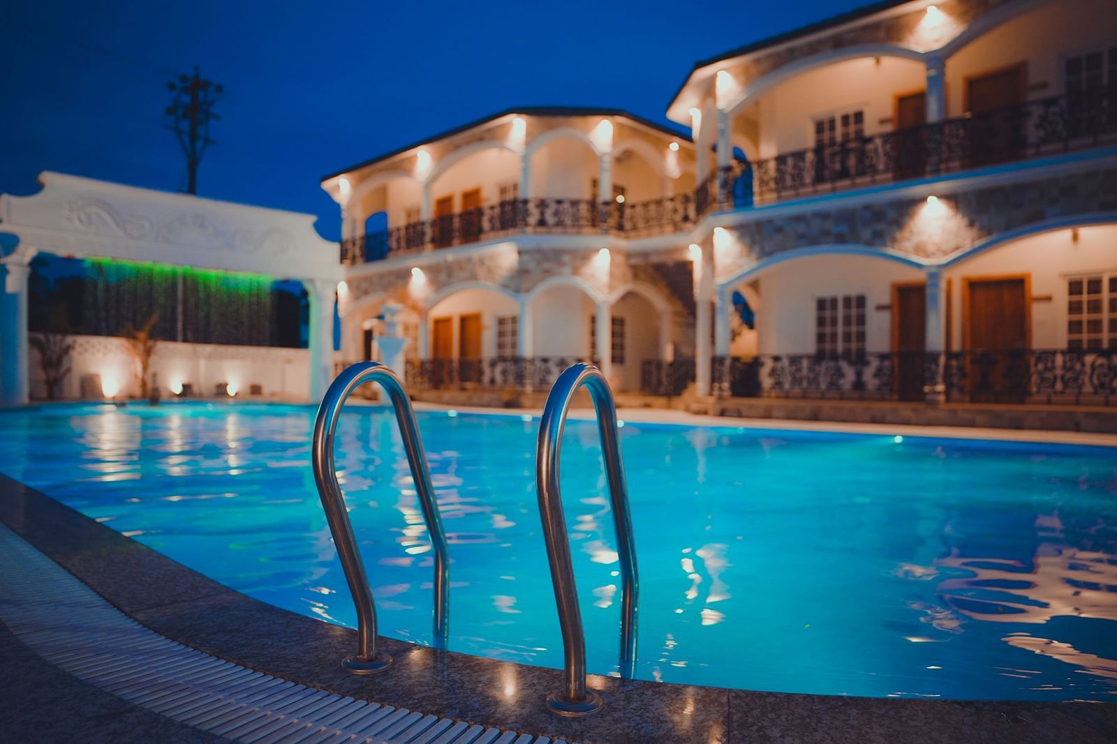 image featuring the stairs leading inside the swimming pool with the facade of dip holidays in the background