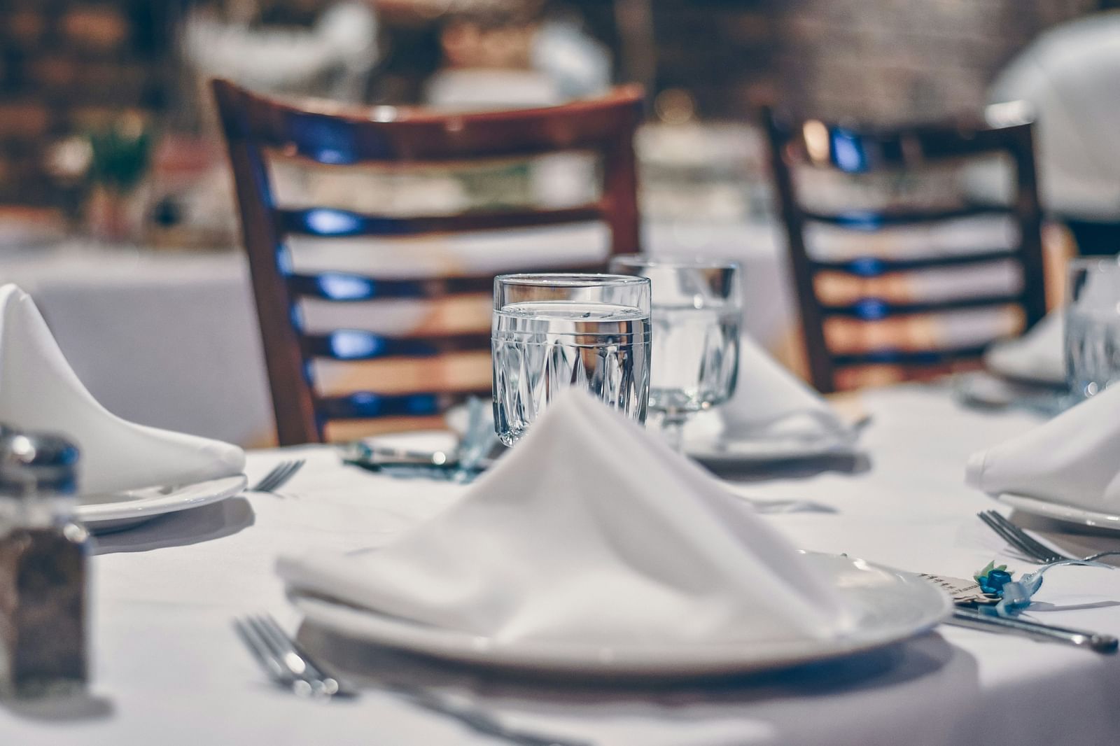 a plate with a napkin placed on it and a glass of water placed by its side