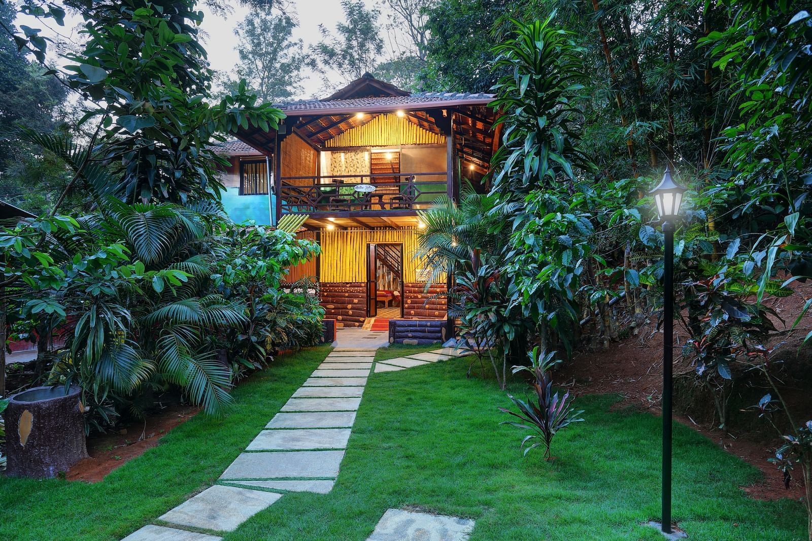 A facade image of the Group Wooden Cottage covered in lush green trees - Evergreen County