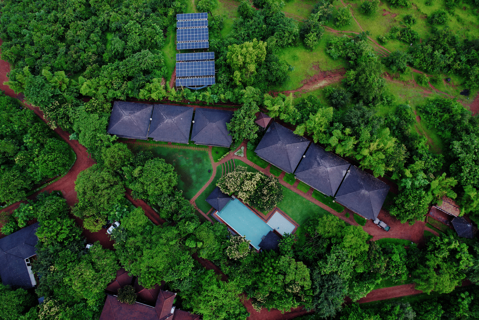 An aerial perspective of Forest Escape reveals cabins nestled in dense foliage, along with a swimming pool.