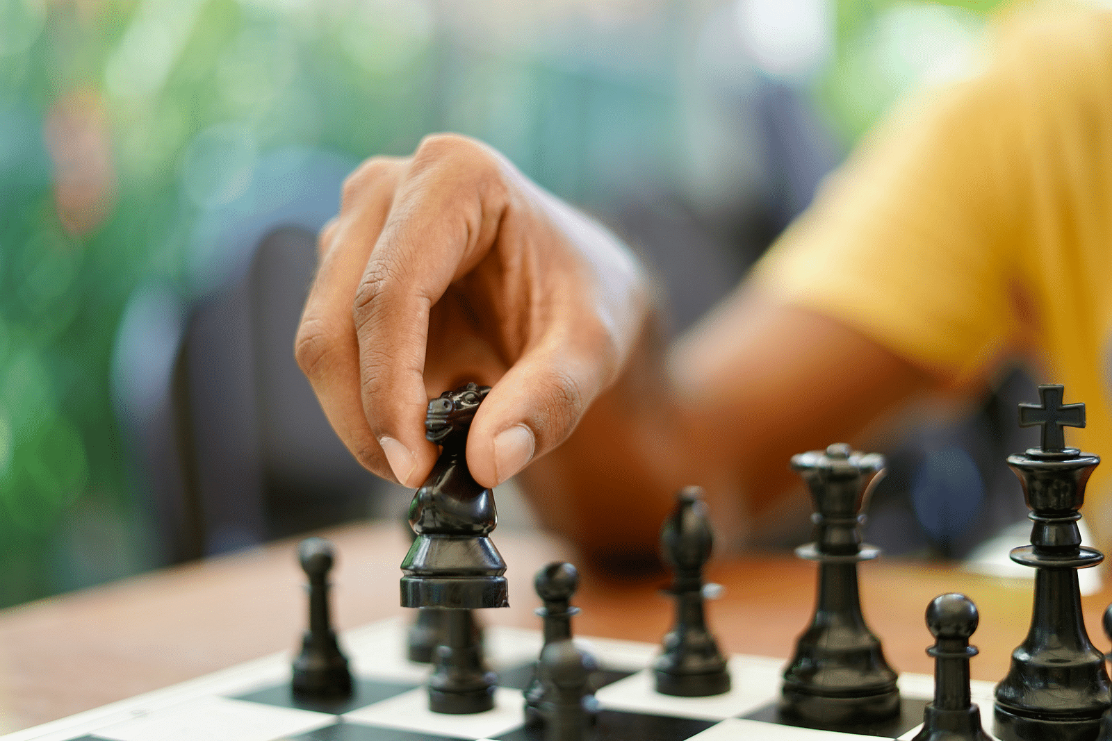A close shot of a person holding a chess piece