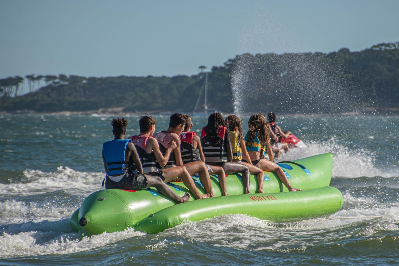 An overview of a group of people riding a banana boat on a waterbody.