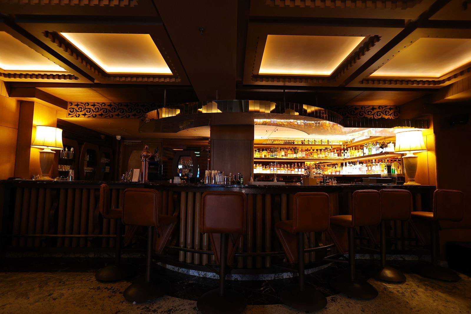 Image of bar area of JBs lounge with chairs, tables and stacked bar rack