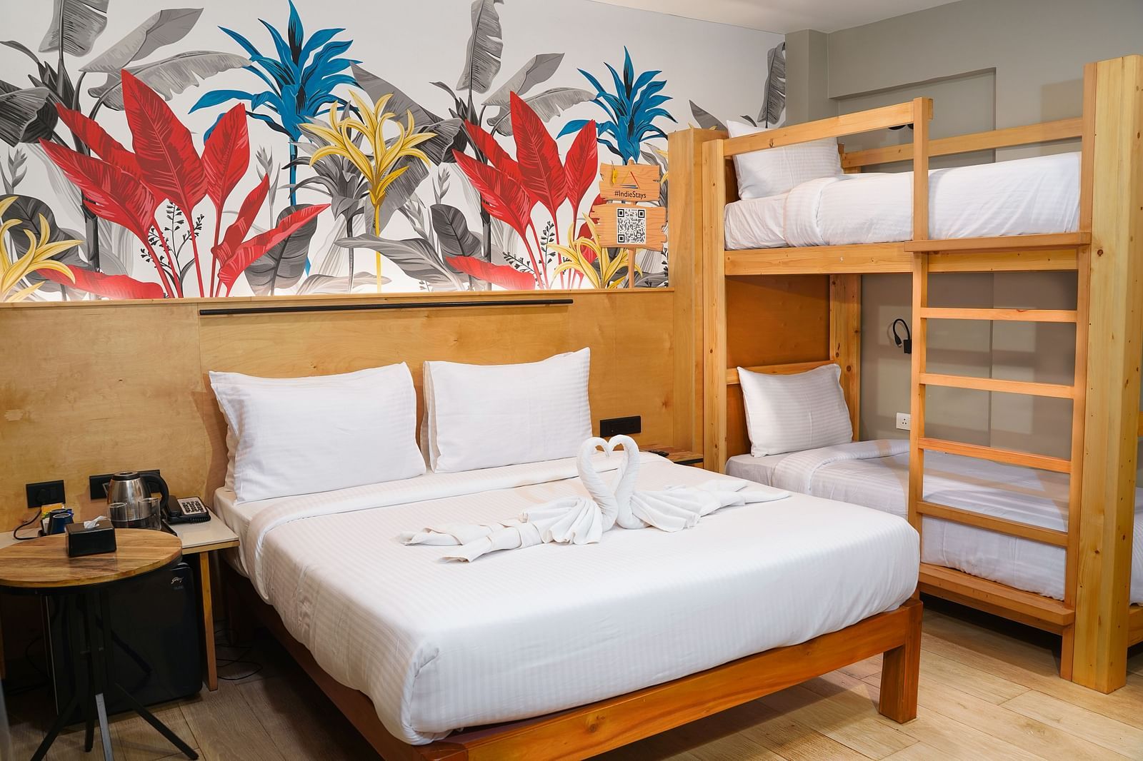 A spacious room featuring a large bed, bunk beds, and a bedside table, offering ample comfort for families or groups at Indie Stays