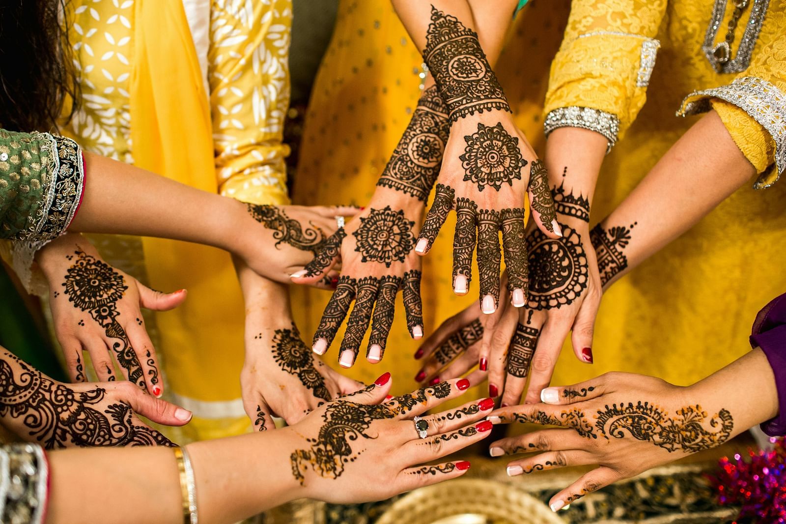 Top view of many pairs of hands with Henna art.