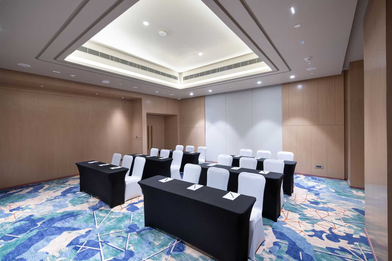 Spacious room with modern U-shaped table arrangement at Merlis Hotel, Coimbatore.