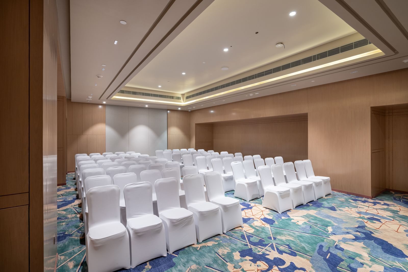 Side view of theatre-style seating arrangement in a function space at Merlis Hotel, Coimbatore.