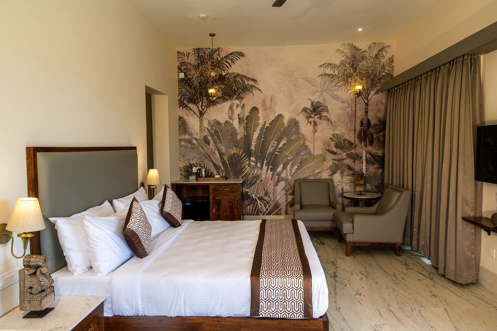 A spacious room with nature-themed wallpaper and elegant decor - Rajbagh Wellness, Udaipur.
