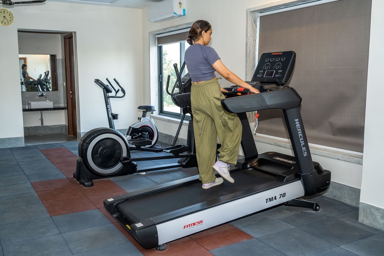 A woman using a treadmill at our gym in Udaipur - Rajbagh Wellness, Udaipur