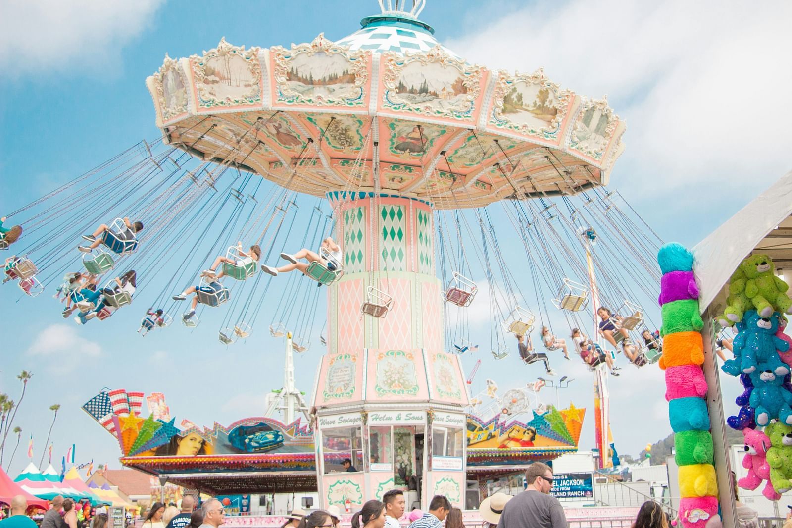 people riding a ride inside an amusement park with blue sky in the background