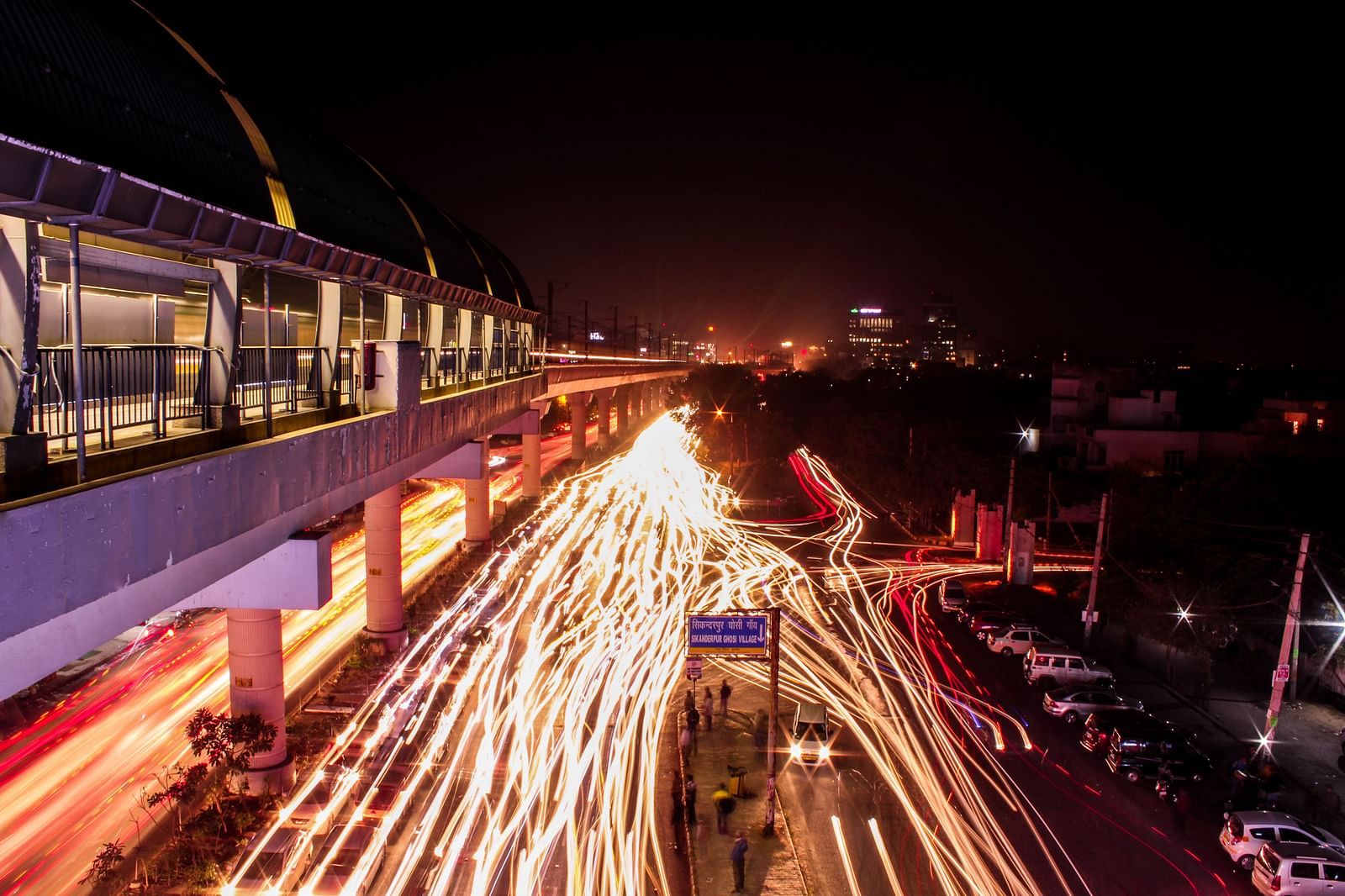 An overview of a metro station with traffic below during the night.