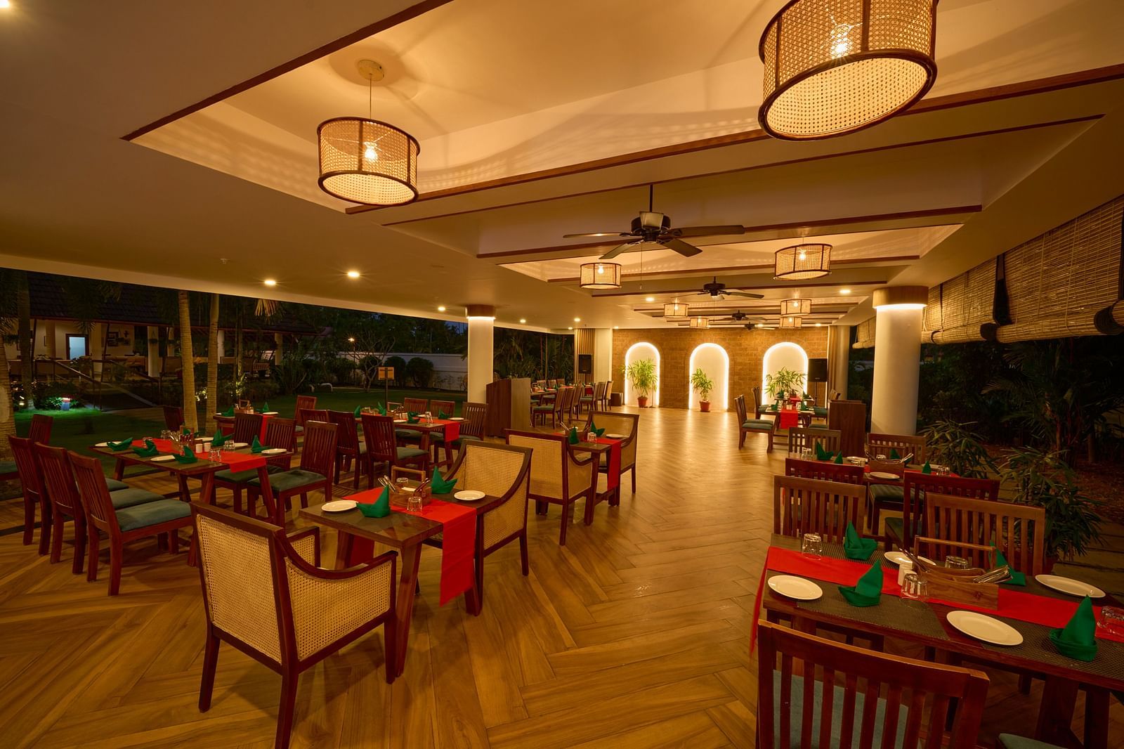 an overview of the seating arrangements inside a restaurant with illuminating yellow lights at Rhythm Kumarakom.