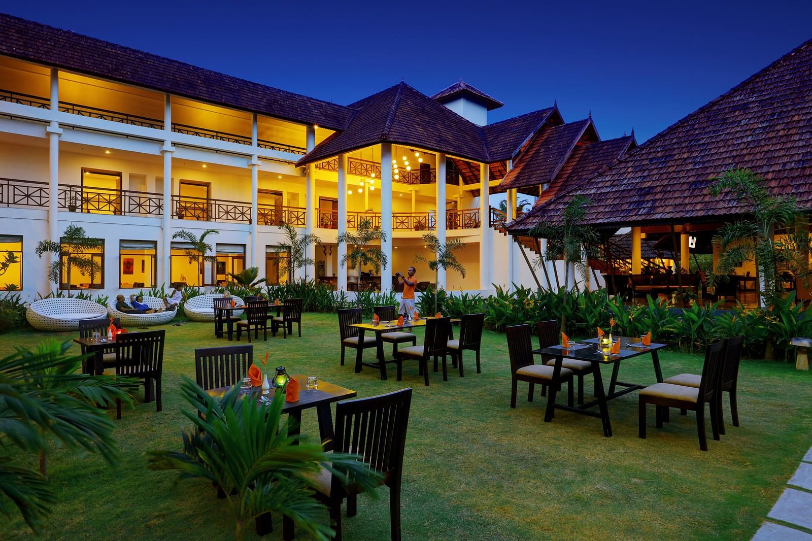 an image of a open dining space with tables and chairs - Rhythm Kumarakom
