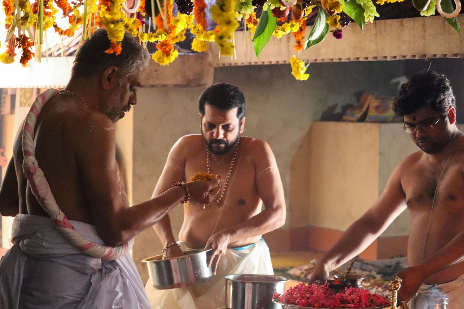 Traditional Hindu priests performing a sacred ceremony with offerings - Kumarakom 
