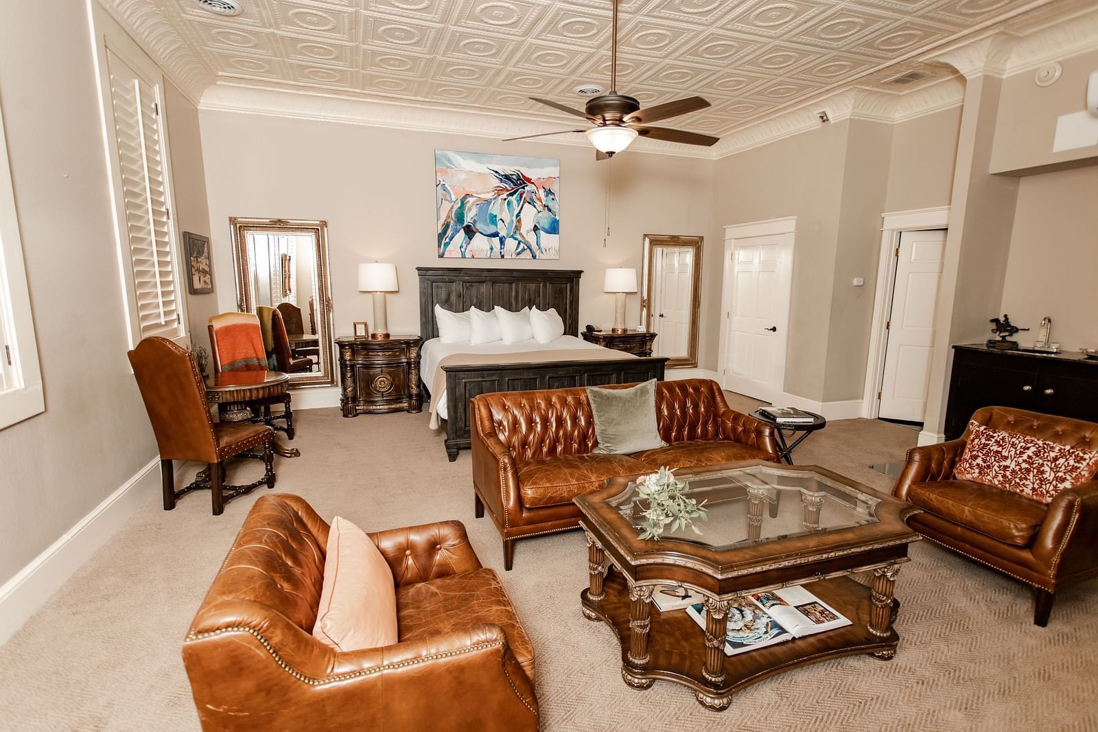 Sitting area with leather chairs, ceiling fan, and glass-top table at The Grand Hotel & Ballroom, McKinney.
