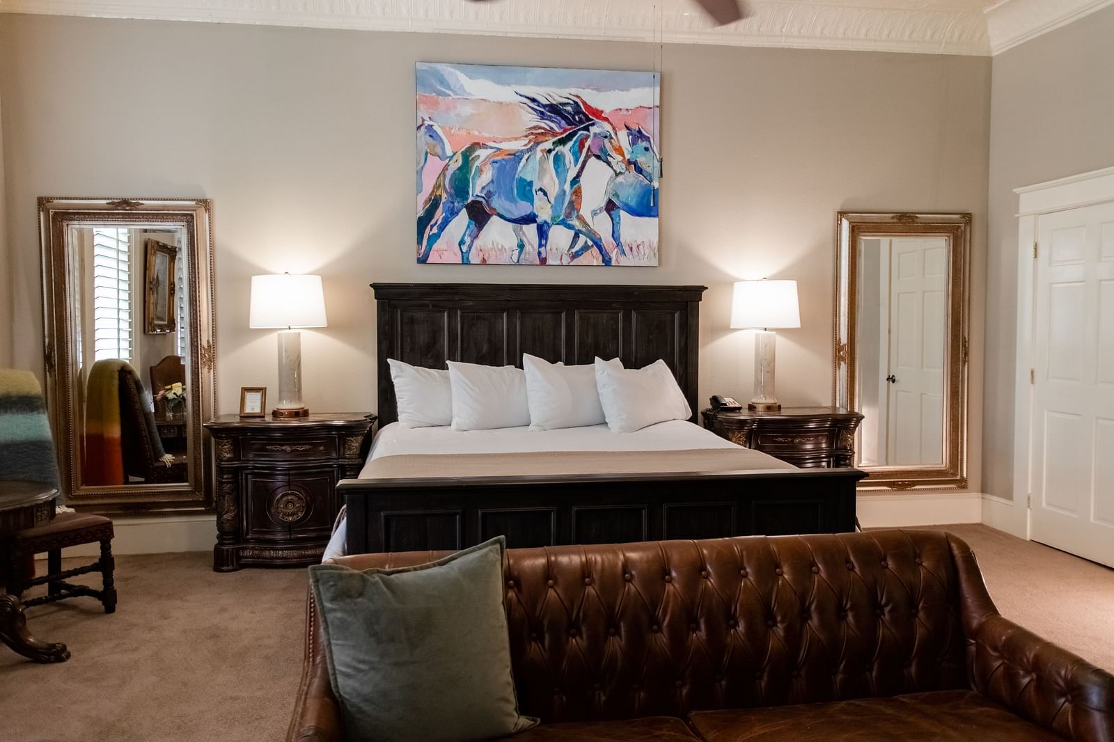 Bedroom with a large bed, nightstands, and artwork at The Grand Hotel & Ballroom, McKinney.