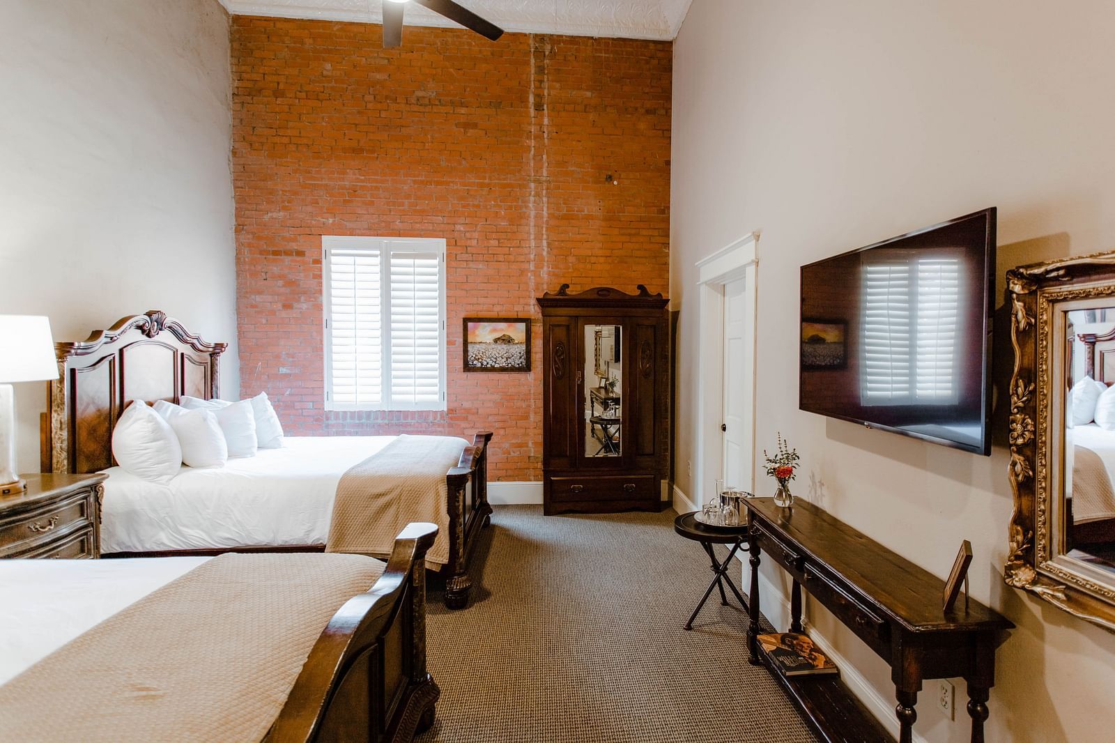A charming bedroom with wooden furniture, elegant decor, and a ceiling fan, offering a serene and classic atmosphere - The Grand Hotel & Ballroom, McKinney