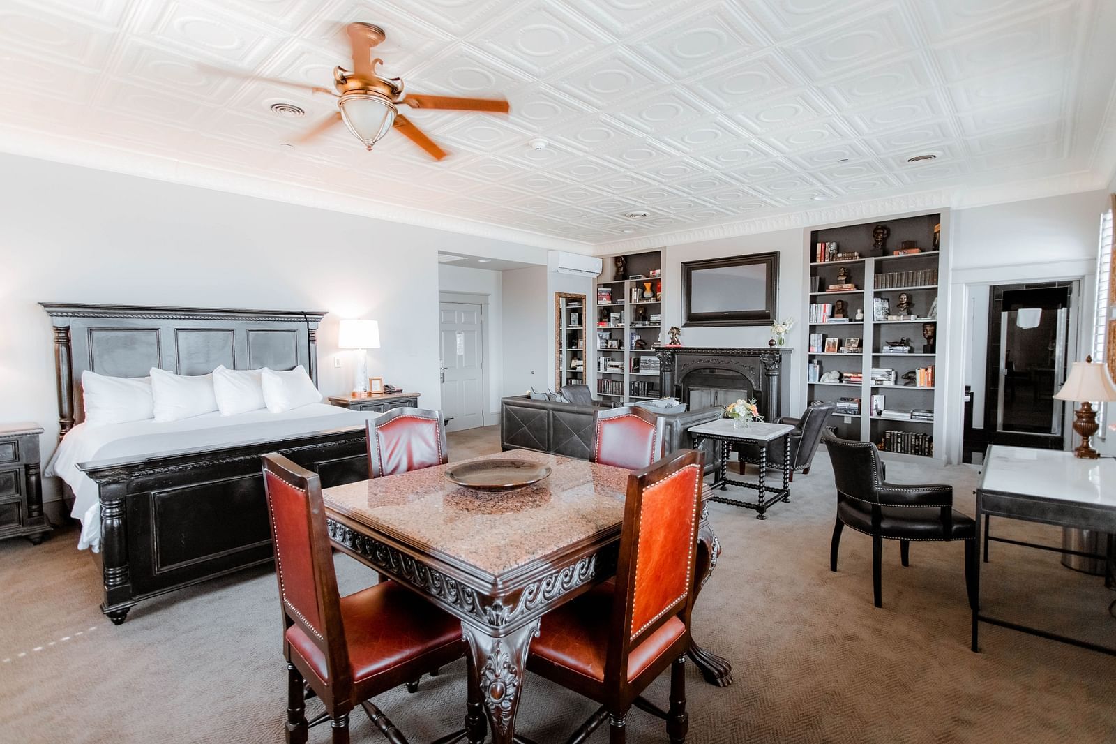 A dining area featuring a wooden table, comfortable chairs, and tasteful decor, offering an inviting place to enjoy meals - The Grand Hotel & Ballroom, McKinney