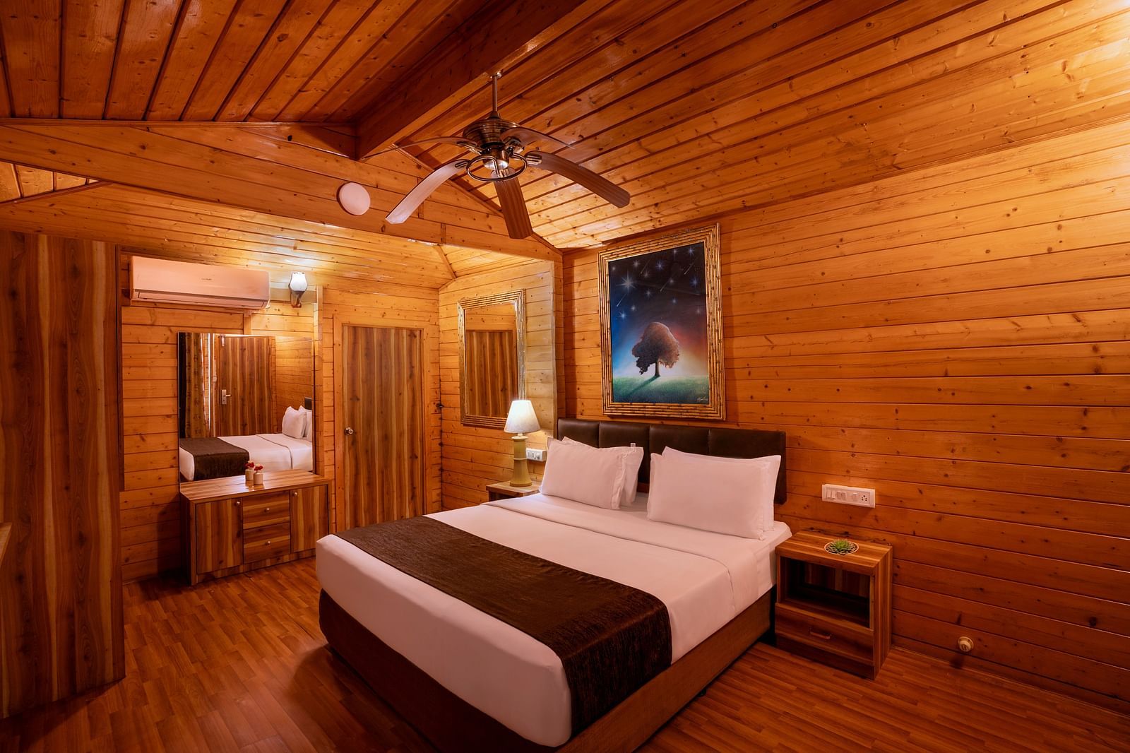 Image of a cosy food with wooden furnishing and king size bed | The Grand Legacy Resort and Spa 