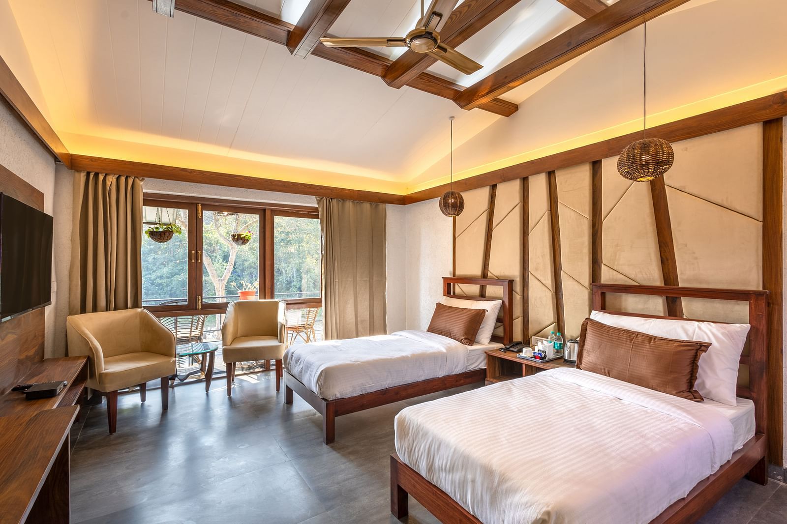 Twin beds facing the TV of River View Room at the Sylvan Retreat, Dehradun. 