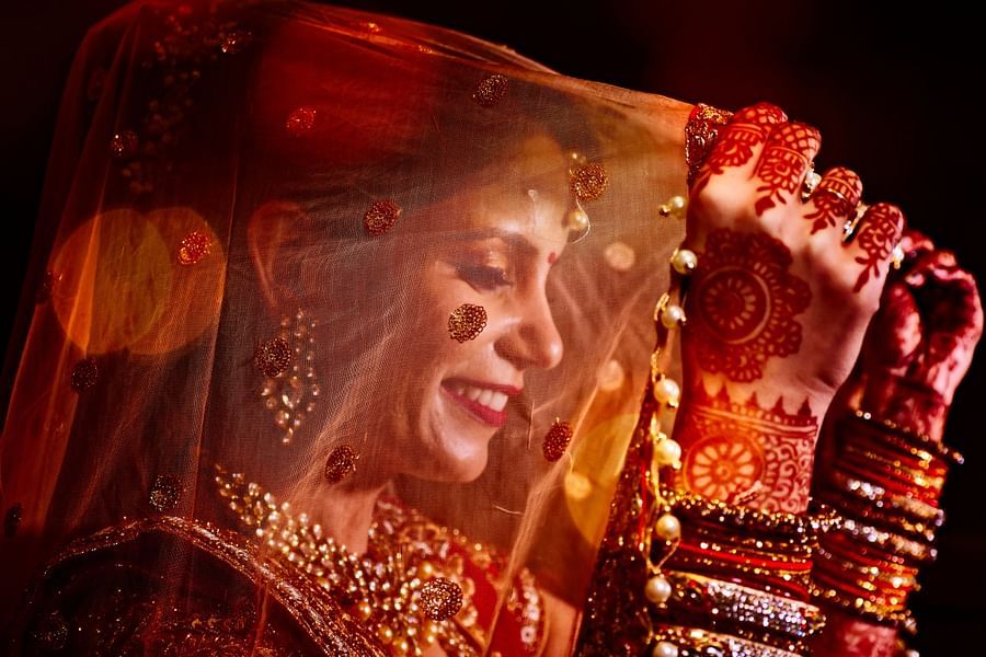 a woman wearing a red attire holding her veil