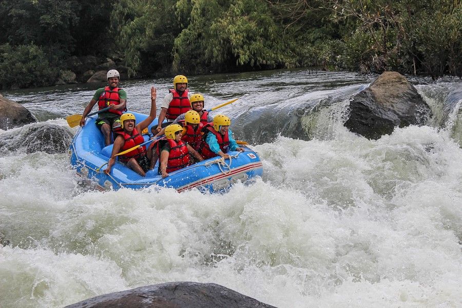 alt-text  A raft with six people in safety gear navigating through a rough river, showing intense concentration and teamwork in an exhilarating environment.
