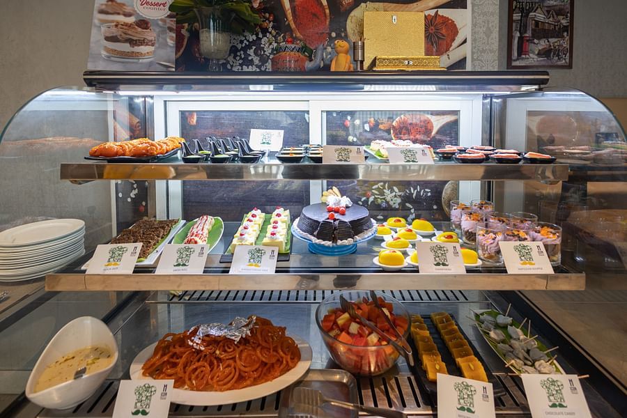 Dessert counter with a variety of desserts in a closed display at Icon Premier Hotel by Bhagini, Devarabisanahalli