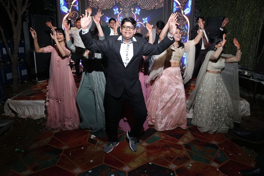 alt-text Group dance with the bride and groom enjoying the performance at Shri Radha Brij Vasundhara Resort & Spa.