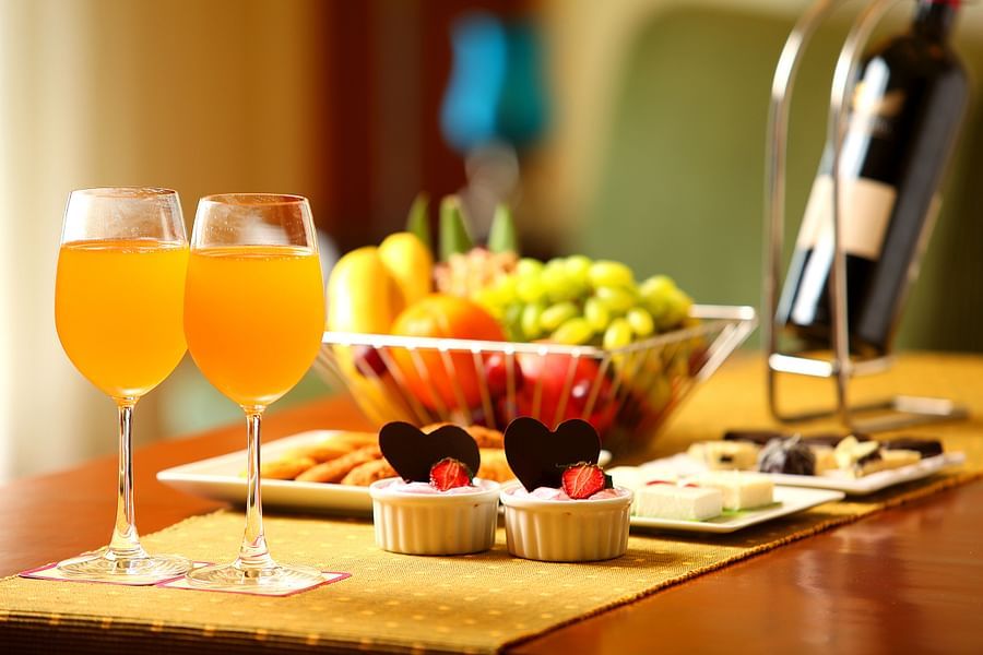 table of two drinks, fruits and desserts