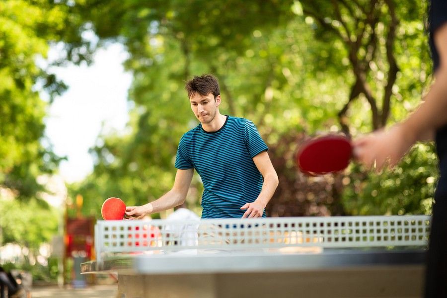 young man playing table tennis in park