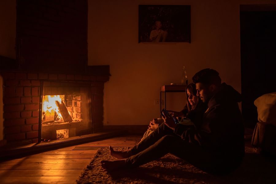 a couple sitting next to the fireplace