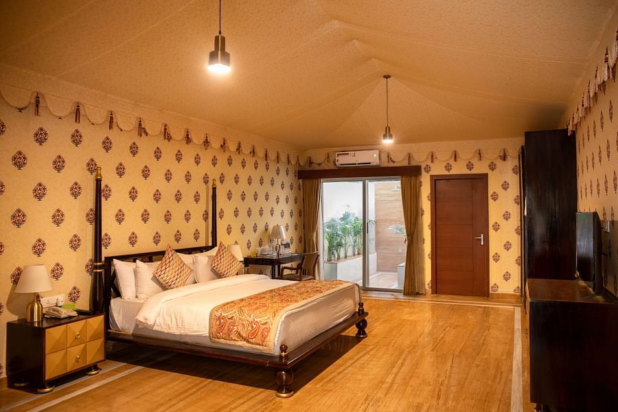 The interiors of our tent suites in Pushkar with a bed, a sofa set and tasteful decor 