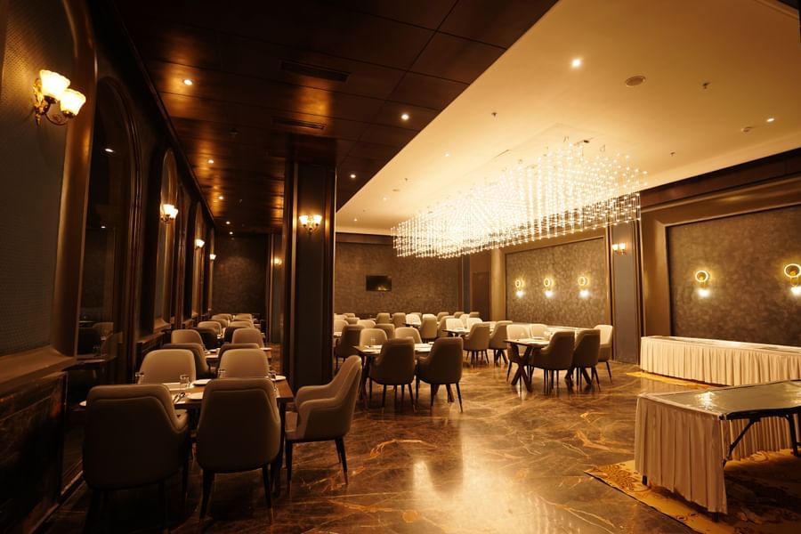 restaurant with tables and chairs with warm lighting at Classic Sapphire by Ananta