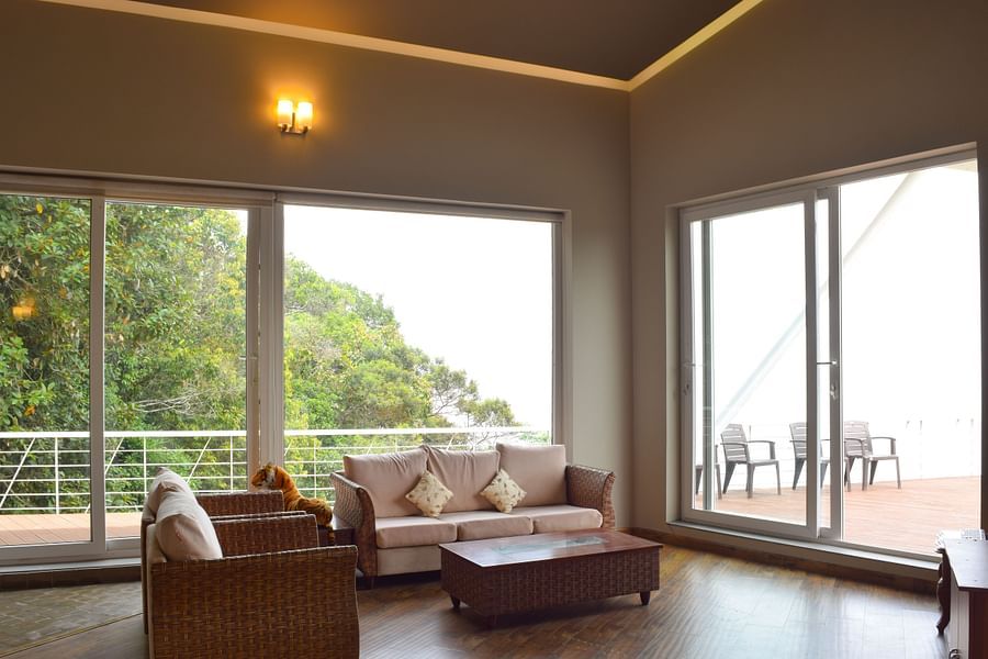 View of indoor lounge with seating area, french windows, cosy setting and wooden flooring at Ibex Resorts, Coonoor (Tapas).