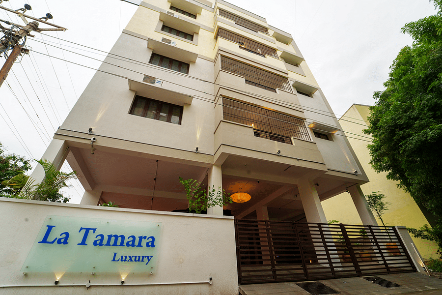 alt-text Facade view of La Tamara Luxury, Pondicherry with a tree next to it