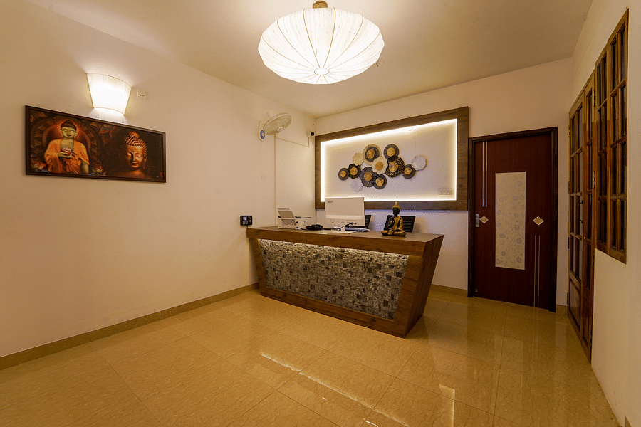 alt-text Reception area with a painting next to the table - La Tamara Luxury, Pondicherry