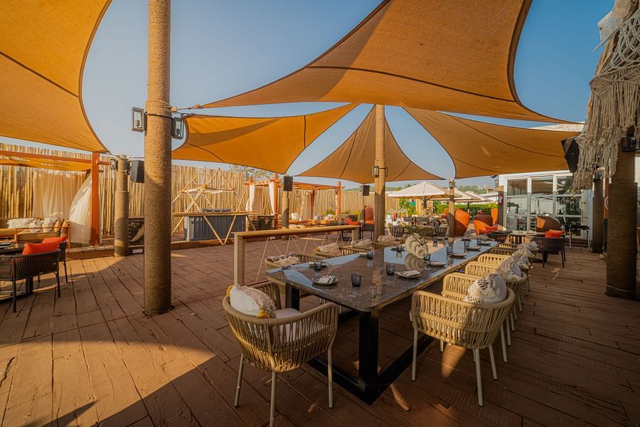 alt-text full angle view of restaurant designed with wooden interior with posh decor facing the beach