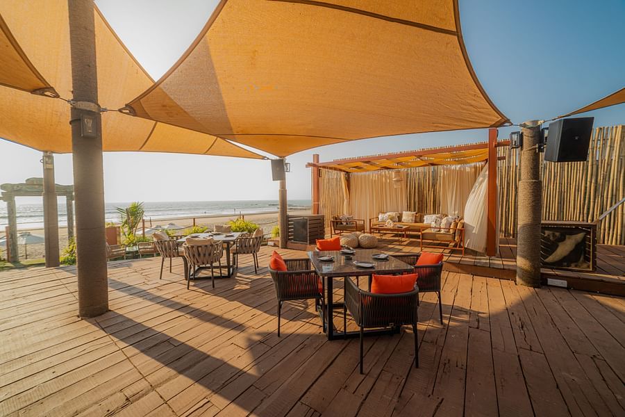 alt-text full angle view of restaurant designed with wooden interior with posh decor facing the beach
