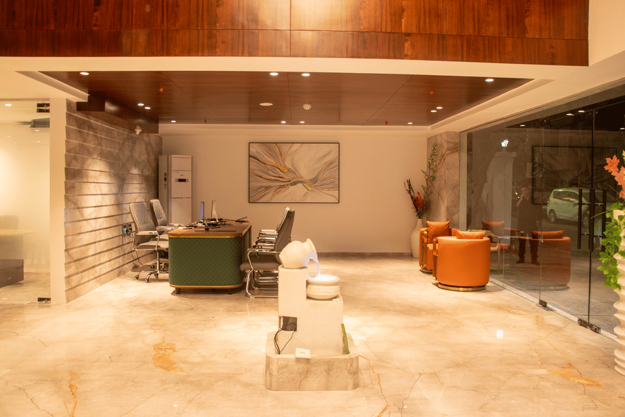 The lobby area with 2 armchairs, reception desk, chairs, and marble sculpture at Magnus Lxia Premier, Kalyani Nagar.