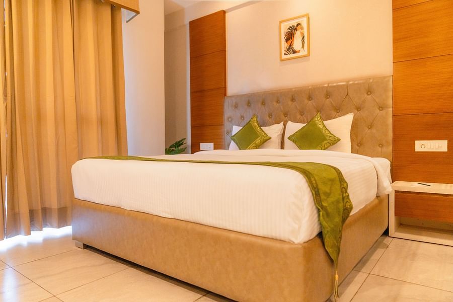 A large bed in a Deluxe Room at Montclair Ananta, Elite.
