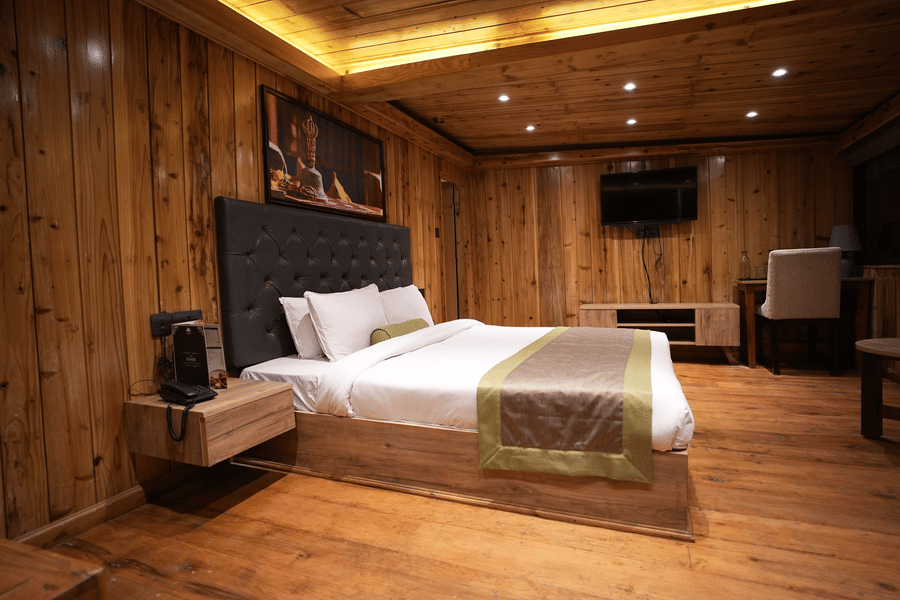 Large bedroom featuring a wide bed, seating area, and soft natural lighting.