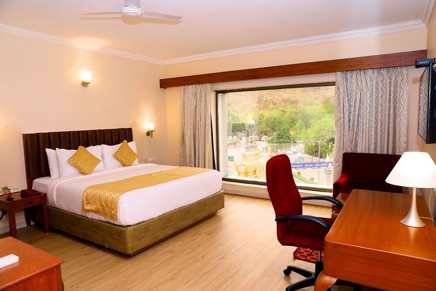 Bedroom with large window and desk chair.