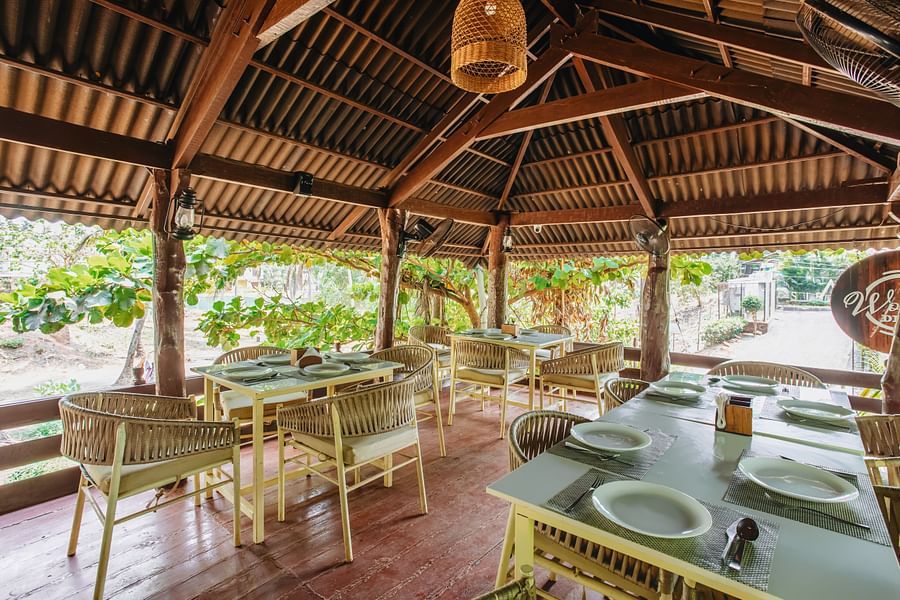 image of the wooden deck with covered seating arrangement surrounded by lush tropical greenery at sibaya beach resort, morjim beach