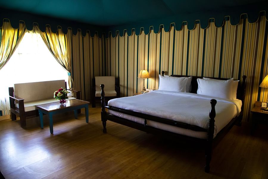 A spacious bedroom with a large bed and a sofa