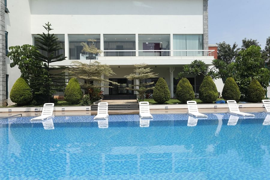 White lounge chairs beside a blue swimming pool