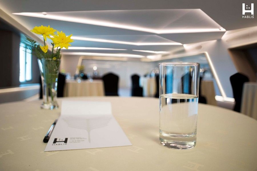 glass of water and a vase on table in boardroom