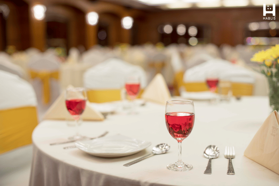 Plates, cutlery and welcome drink on the table at Hablis Hotel, Chennai.