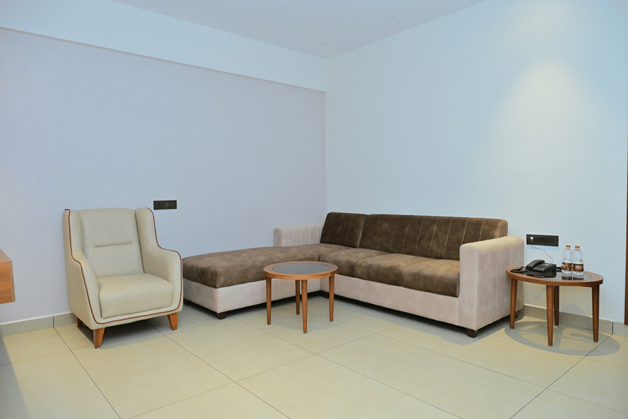Lounge area of Bhavanis Vista By Icon featuring a sofa, an armchair, and a coffee table.